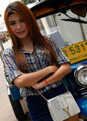 Exotic legal teen with red hair demonstrates her braces while posing near rickshaw