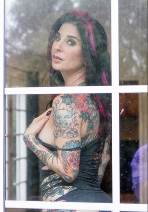 Pornography queen strips in front of the glass door and furthermore continues posing on the sofa