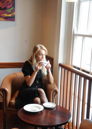 Nerdy-looking blonde gets slutty and hikes up her black dress to show panties