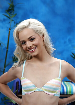 Slim blonde barbie smiles while posing in knee socks only by the massage table