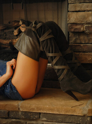 Young-looking broad with bangs brags about her wonderful bum by the fireplace