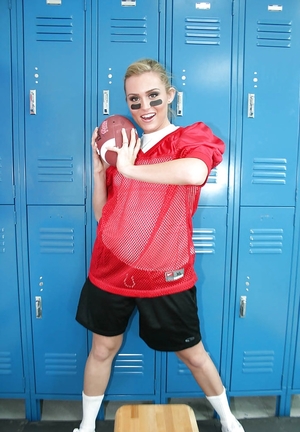 Woman football player prepares for game by posing undressed in locker room