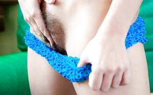 Redheaded beauty with a subtle smirk showing off her legs