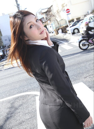 Redheaded Japanese broad in suit poses to show her nice-looking face