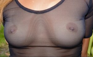 Sweet blonde walks in garden dressed in transparent top and pantyhose