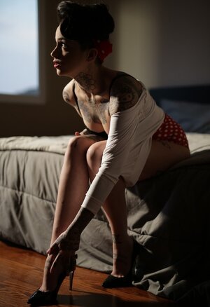 Inked brunette has a sufficient amount talent to pose nude in image of pinup adult model