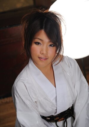 Attractive young Japanese lady in a kimono participates in erotic photo session