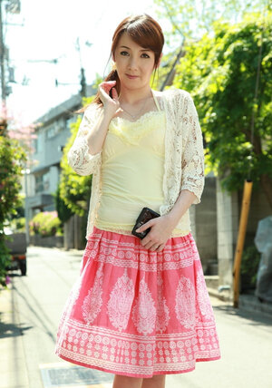 Asiatic beauty with red hair seductively walks on sunny street of big city