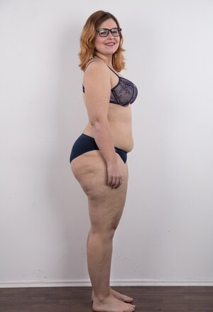 Heavyweight slut with glasses rocks out in the pornography studio trying striptease skills out