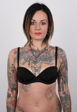 Diva with bright lipstick and additionally tattoos all over her body exposes shaved twat