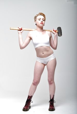 Pale-skinned slut with short red hair and moreover tongue piercing holds sledgehammer