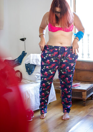 Plus-sized redhead on pink underwear to get fully dressed next to the window