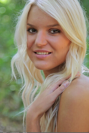 Blonde with tan lines demonstrates her splendid nude body in the forest