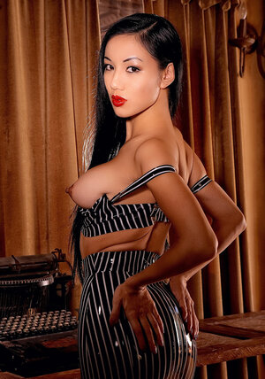 Raven-haired Oriental stunner removes latex suit to expose her slim body