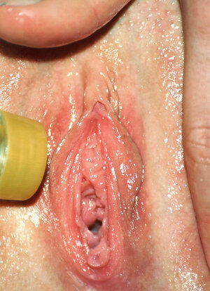 Curly-haired gal with tanned oiled body attracts attention to her wet vag