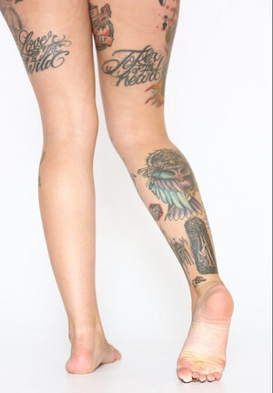 Appealing xxx star in black bra and pants prefers to pose with undressed tattooed body