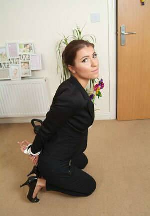 Office chick in high heels in a strict tuxedo suddenly gets bound up on the floor