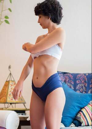 Young and fresh brunette Anais puts blue panties on after posing on the camera